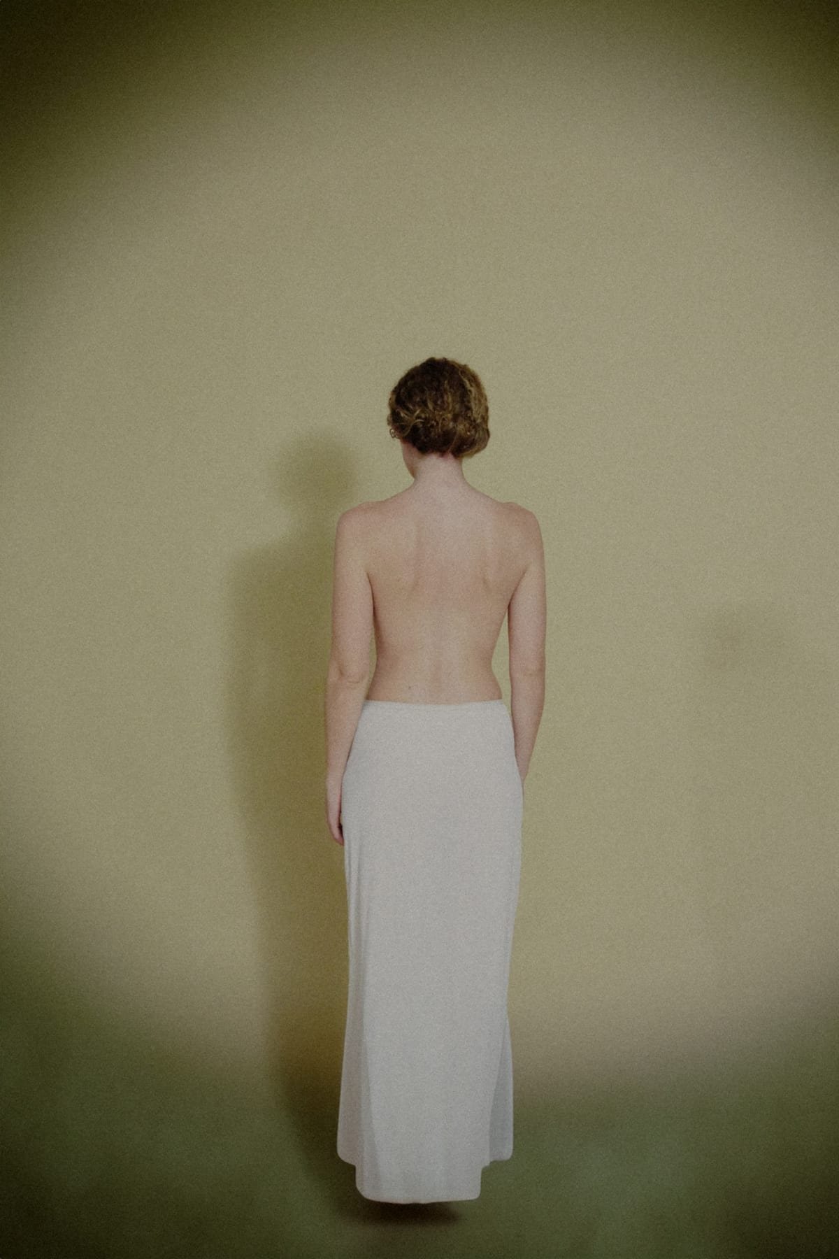 Bare back portrait against a wall
